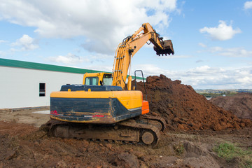 Work of special equipment at a construction site. Crawler excavator performs earthwork.