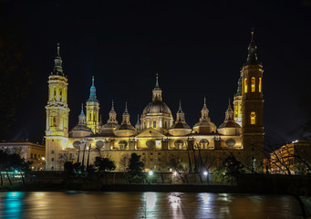 Fototapeta na wymiar Cathedral Basilica of Our Lady of The Pillar at night with reflections on Ebro River in Zaragoza, Spain