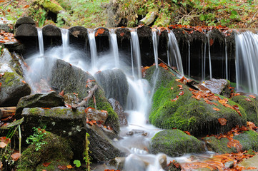 Fototapeta na wymiar Mountain waterfall in autumn forest