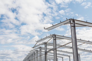 Construction of agricultural buildings. The frame of the roof of the new barn for cows. Construction of a new barn. Wooden beams on a metal frame. 