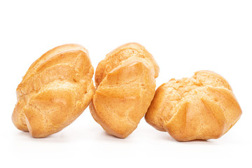 Group of three whole baked golden profiterole in line isolated on white background
