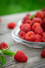  Pink fresh raspberries on an glass vessel on a gray wood background in the garden on the background of green grass Berry Fruit Sadovina Healthy Food hack close up