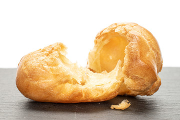 Group of two halves of baked golden profiterole on grey stone isolated on white background