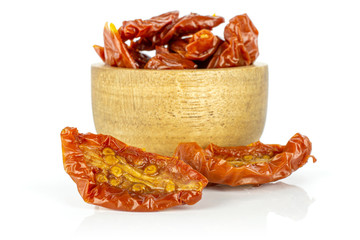 Lot of slices of dry red cherry tomato in wooden bowl isolated on white background