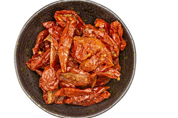 Lot of slices of dry red cherry tomato on grey ceramic plate flatlay isolated on white background
