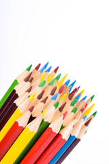 Many different colored pencils on a white background with a place for text and cory space .