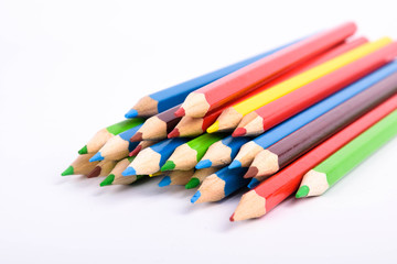 Fototapeta premium Many different colored pencils on a white background with a place for text and cory space .