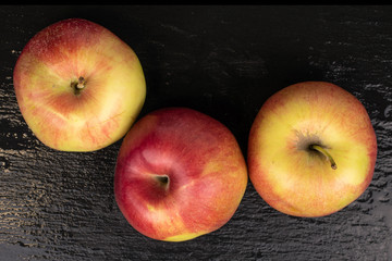 Group of three whole red apple jonagold flatlay on grey stone