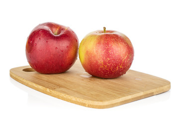 Group of two whole red apple jonagold on bamboo cutting board isolated on white background