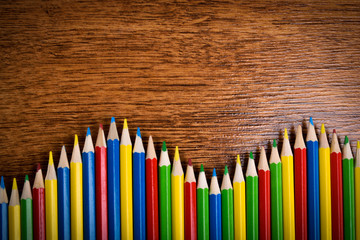 Obraz premium Different colored pencils on the brown wooden table background .Top view .Close up .Color .Pencil.Set