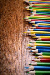 Different colored pencils on the brown wooden table background .Top view .Close up .Color .Pencil.Set