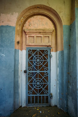 Old door with iron ornate forged grid 