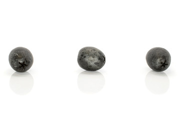 Group of three whole tasty black olive isolated on white background