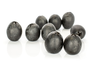 Group of nine whole tasty black olive front focus isolated on white background