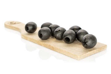 Lot of whole tasty black olive on wooden board isolated on white background