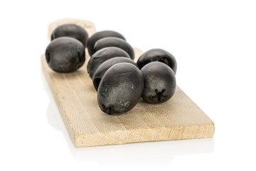 Fototapeta na wymiar Lot of whole tasty black olive on wooden board isolated on white background