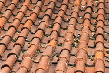 Partially damaged roof tiled with imbrices and tegulae. Photo in perspective with selective focus
