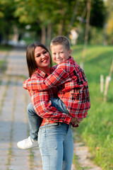 Mom, smiling broadly, holds her son in her arms.