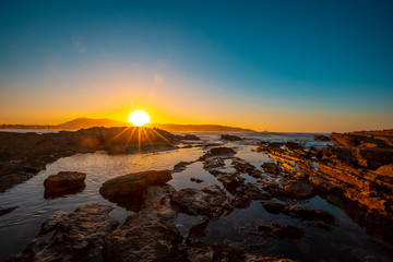 Last moments of the blue autumn sunset at low tide in Hendaye. France