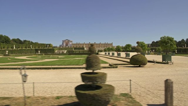 Tracking pan shot shot right to left of the territory and alleys of gardens of Versailles in spring time at daylight