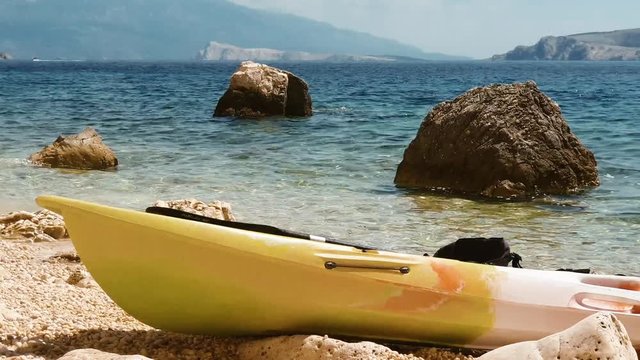 Kayak lying at a lonely beach swinging with the waves on krk island in croatia beautiful water and sun