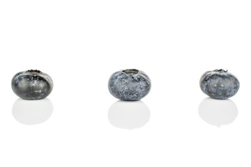Group of three whole fresh blue blueberry isolated on white background