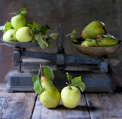 , Apples and pears on an old balance exempted on a dark background