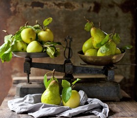 , Apples and pears on an old balance exempted on a dark background