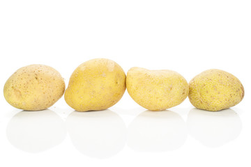 Group of four whole raw brown potato isolated on white background