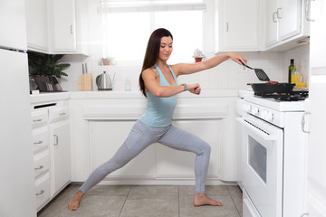 Fototapeta na wymiar Fit female cooking and exercising at the same time, funny lifestyle advertisement, yoga pose in tiny home