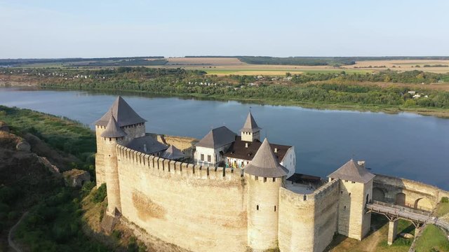 Aerial view of old castle near the River. Hotyn Castle in Ukraine. Eastern Europe. Tilt down.