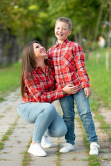 Fototapeta premium Mom and son are smiling happily on a walk in the park.