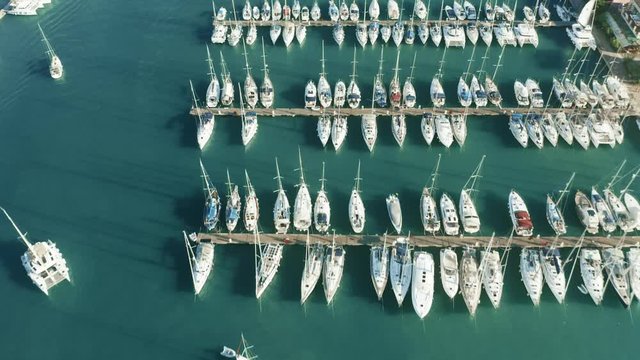 Aerial down view of docked sailing yachts and catamarans in marina
