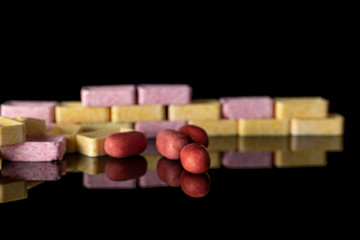 Lot of whole sweet pastel candy wall isolated on black glass