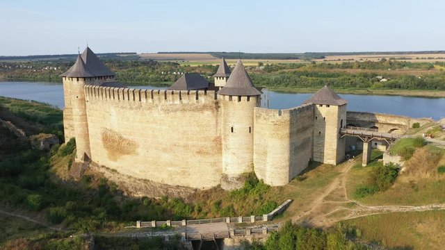 Aerial view of old castle near the River. Hotyn Castle in Ukraine. Eastern Europe. Tilt up.