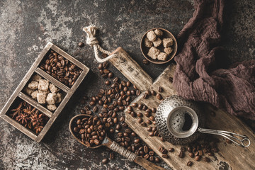 Fototapeta na wymiar Coffee on wooden board with coffee beans on dark textured background. Top view with copy space. Background with free text space.