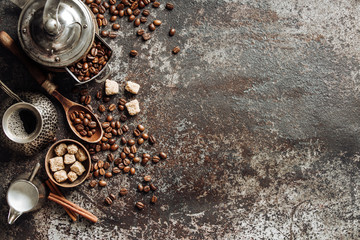 Coffee cup with coffee grinder and coffee beans on dark textured background.