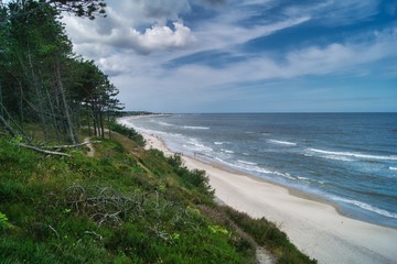 widok na klif bałtycki i piaszczystą plażę w okolicach Ustki, las sosnowy na wysokim brzegu