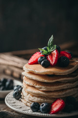 American pancakes with fresh berry on wood background. Summer homemade breakfast.