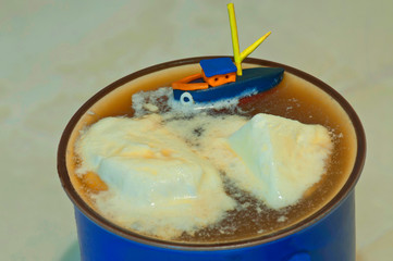 Little ship in a cup of tea with ice-cream