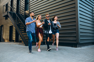Fototapeta premium Group of stylish friends, girls and guys walk together on in the city