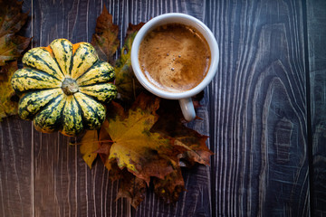 Pumpkin spiced latte on a wooden table with autumn leaves and a pumpkin. Blogging workshop concept. Flat lay and copy space.