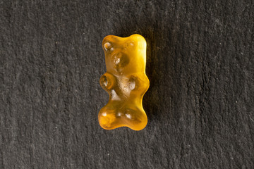 One whole gummy bear flatlay on grey stone