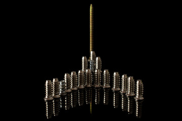 Group of seventeen whole metallic glossy bolt building isolated on black glass