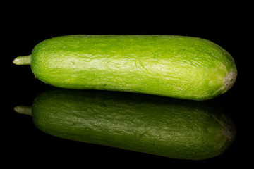 One whole mini green cucumber isolated on black glass