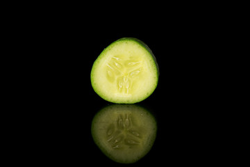 One piece of mini green cucumber isolated on black glass