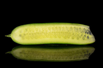 One half of mini green cucumber isolated on black glass