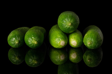 Lot of whole mini green cucumber isolated on black glass