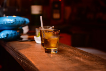 glass of whiskey on wooden table, wooden bar counter