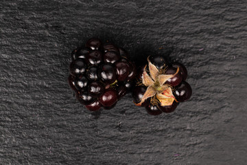 Group of two whole fresh black blackberry flatlay on grey stone